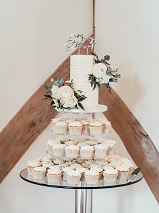 2 tier wedding cake with cupcakes